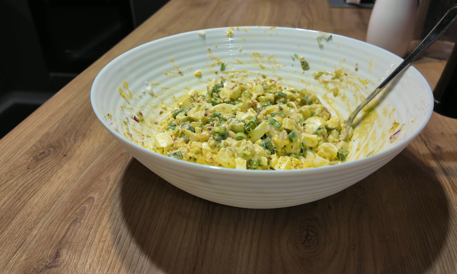 Gotowa pasta jajeczna z rzodkiewką i szczypiorkiem w misce.